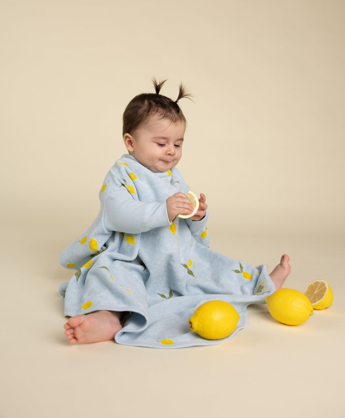 Baby mit Little Casimir Lätzchen Lemon Sorbet, spielt mit Zitronen